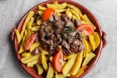 Picado: Fleischstücke in Sauce mit Pommes frites