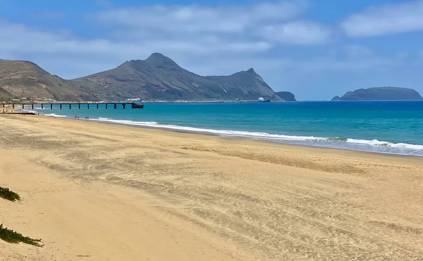 Sandstrand von Porto Santo mit Pier und Bergen